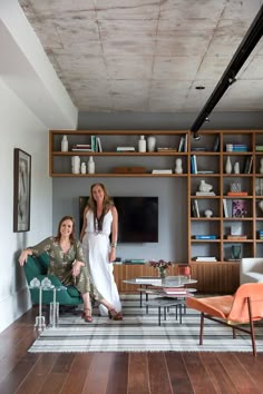 two women are standing in the living room