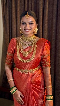 a woman in an orange and gold sari