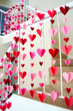 paper hearts are hanging from the banisters in this staircase decorated for valentine's day