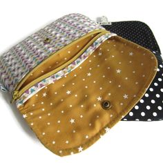 three zippered pouches with white stars and polka dots on them, all lined up in different colors