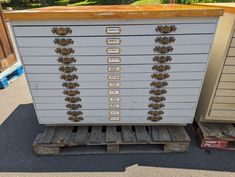 an old chest of drawers sitting on top of pallets in front of other boxes