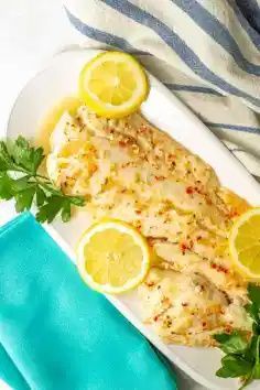 fish with lemons and parsley on a white plate