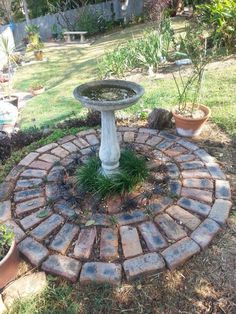 a bird bath sitting in the middle of a garden