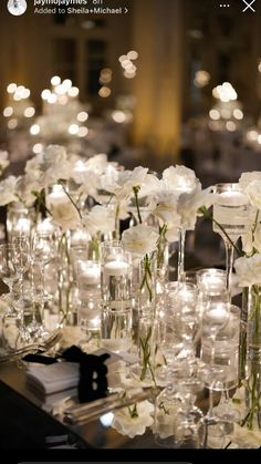 the table is set with candles and flowers in glass vases on top of each other