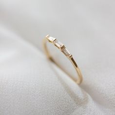 a diamond ring sitting on top of a white cloth