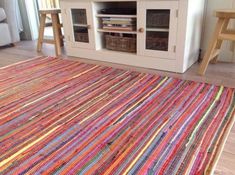 a living room with a colorful rug and entertainment center