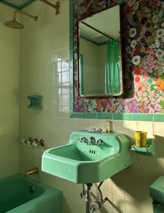 a green sink sitting under a bathroom mirror next to a bath tub and shower head