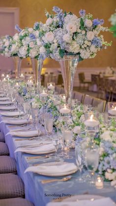 a long table is set with white and blue flowers