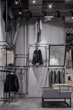 a clothing store with clothes hanging on the wall and other items in the room behind it