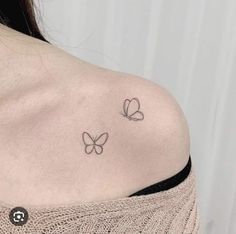 two small butterflies on the back of a woman's shoulder, one is black and white