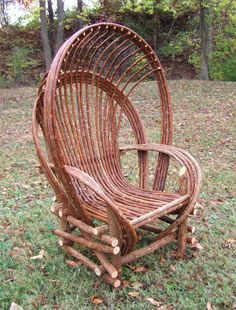 a chair made out of branches sitting in the grass