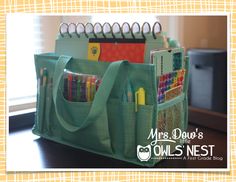 a green bag filled with lots of pens and pencils