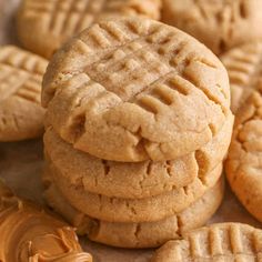 peanut butter cookies stacked on top of each other with the rest of the cookies in front