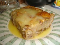 a piece of food sitting on top of a green and white plate covered in gravy