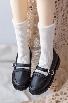 the doll is wearing black shoes with white socks