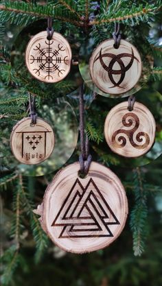 four wooden ornaments hanging from a christmas tree with celtic symbols on them and an ornament in the middle