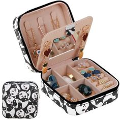 an open suitcase with jewelry in it and panda print lining the bottom half, on a white background