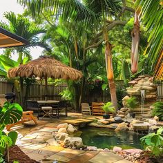 a small pond surrounded by palm trees in a tropical garden with chairs and umbrellas