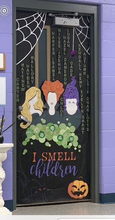 a door decorated with the words i smell children and three witches on it in front of a purple wall