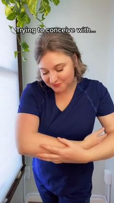 a woman in scrubs is holding her elbow