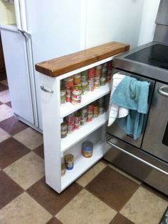 a kitchen with an oven, stove and spice rack on the floor in front of it