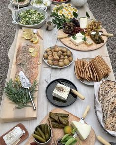 a table full of different types of food on plates and serving platters with cheeses