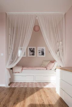 a bedroom with pink walls and white curtains