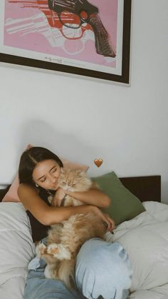 a woman laying in bed holding a cat