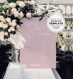 a menu with white flowers in a vase on top of a table next to a sign that says spa menu