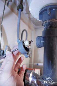 a person fixing a water heater in a kitchen