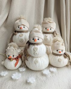 a group of snowmen sitting next to each other on top of a white blanket