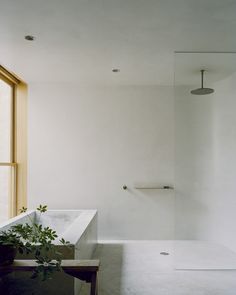 a bathroom with a sink, toilet and bathtub next to a window in the corner