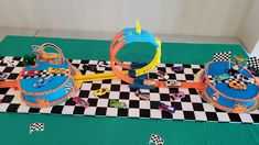 a table topped with cakes and toys on top of a checkered table cloth