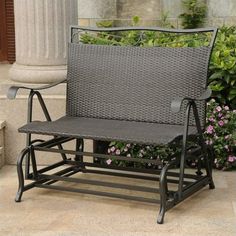 a chair sitting on top of a patio next to a planter filled with flowers