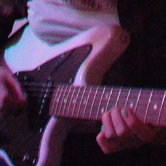 a person playing an electric guitar in a dark room