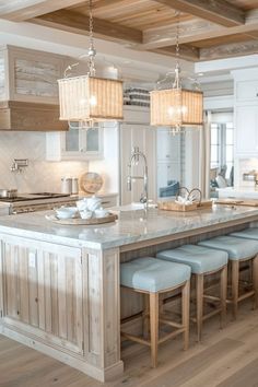 a large kitchen with an island in the middle and four stools at the end