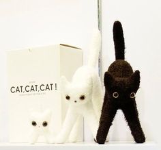 two stuffed animals sitting on top of a white shelf next to a box and cat figurine