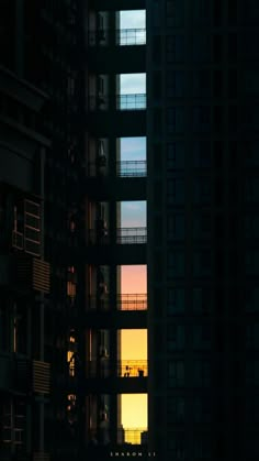 the sun is setting in front of some tall buildings with balconies and balconies