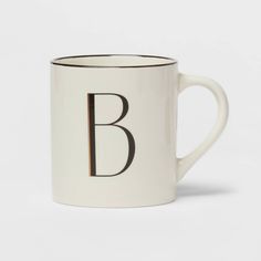 a black and white coffee mug with the letter b on it's side, in front of a white background