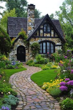 a stone house surrounded by flowers and greenery