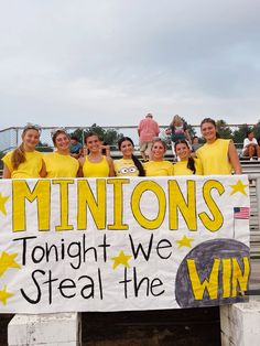 a group of girls in yellow shirts holding a sign that says, minionss tonight we steal the win