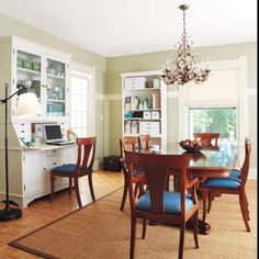 a dining room table with blue chairs and a chandelier hanging from the ceiling