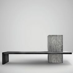 a bench made out of concrete blocks sitting in front of a white wall and floor