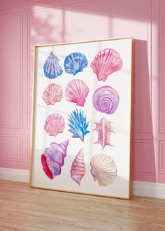 a framed photo with seashells on it in front of a pink painted wall