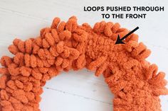 a close up of an orange wreath with the words loops pushed through to the front