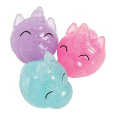 three different colored plastic toys with faces on them