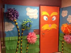 the door is decorated with colorful paper flowers and palm trees, which look like dr seuss