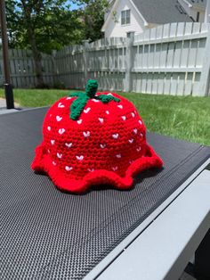 a knitted strawberry hat sitting on top of a table