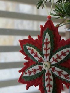 a christmas ornament hanging from a tree with snowflakes on the top