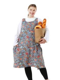 a woman in an apron holding a bag full of bread and buns on a white background